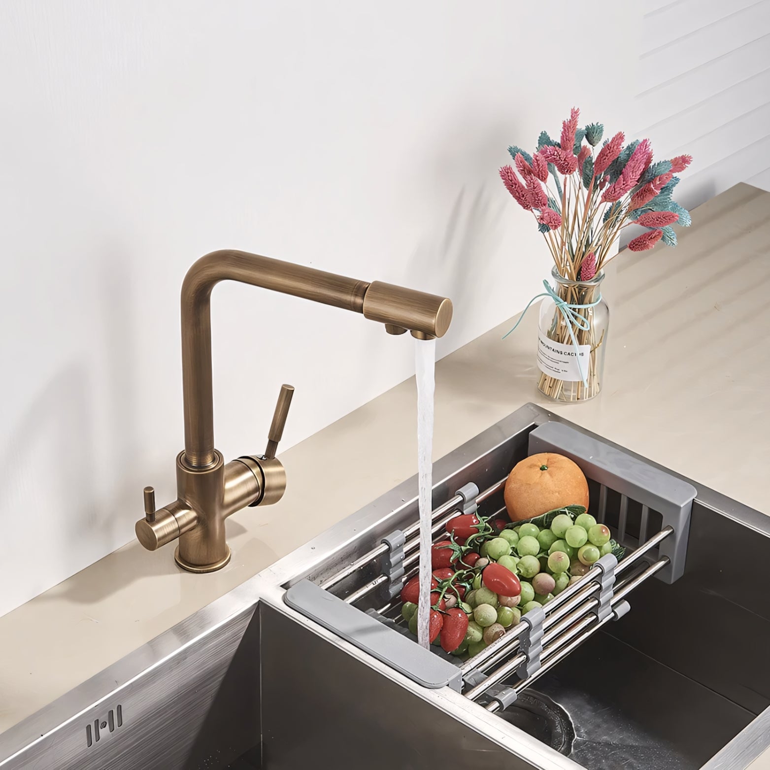 Kitchen sink with bronze faucet, running water, and fruits and vegetables inside.