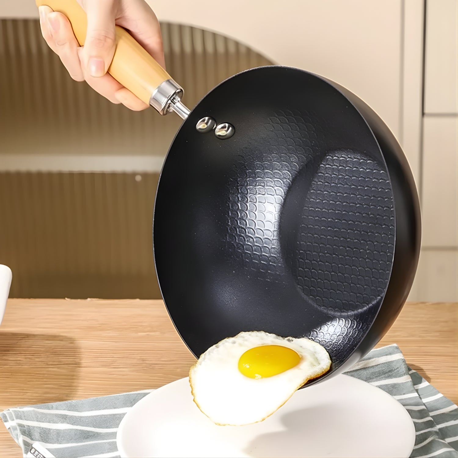 Person holding a black wok with a fried egg on a plate