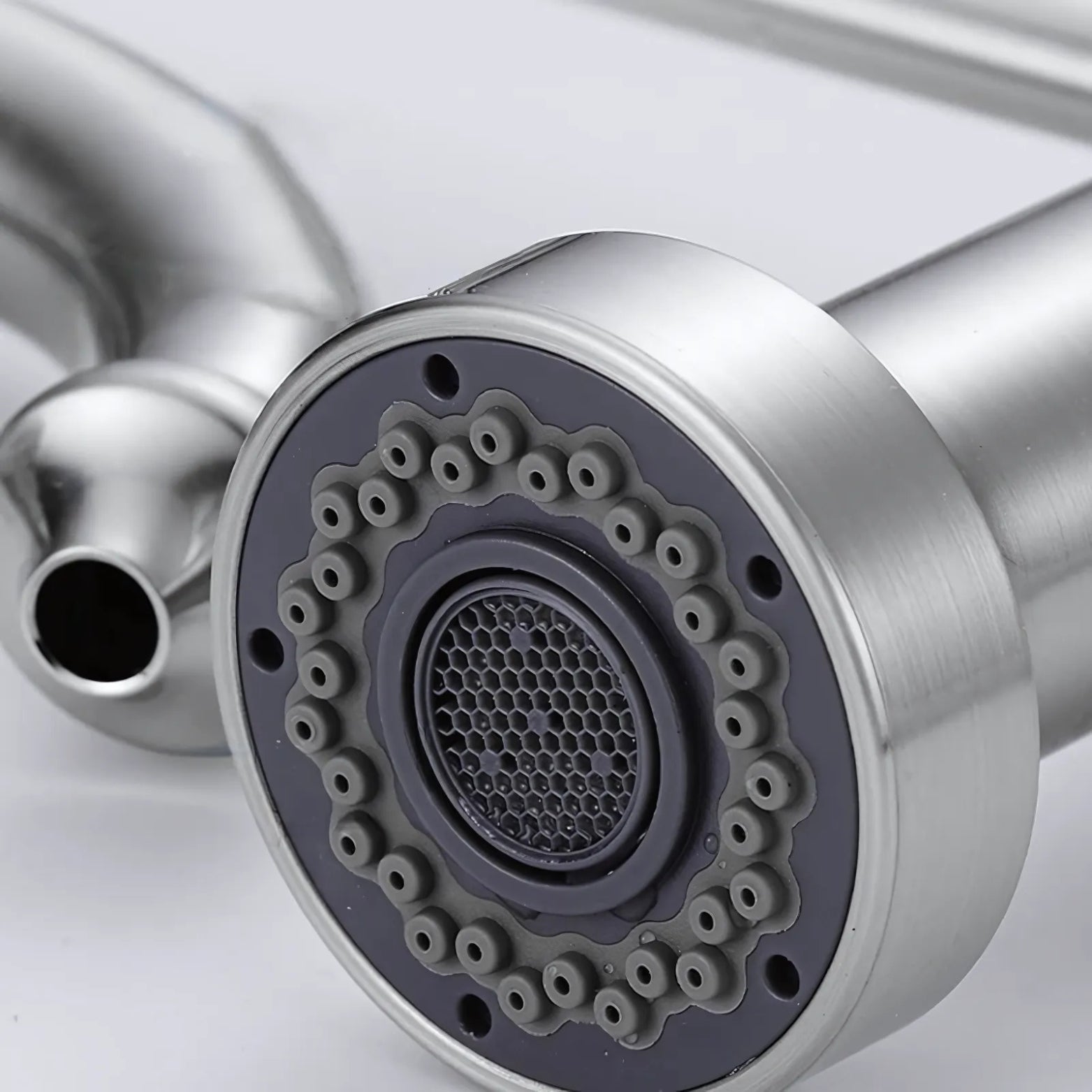 Close-up of a metallic kitchen faucet handle on a light gray background