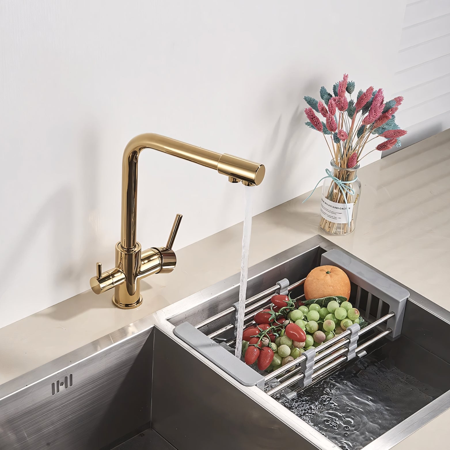 Modern kitchen sink with gold faucet and fruit being washed