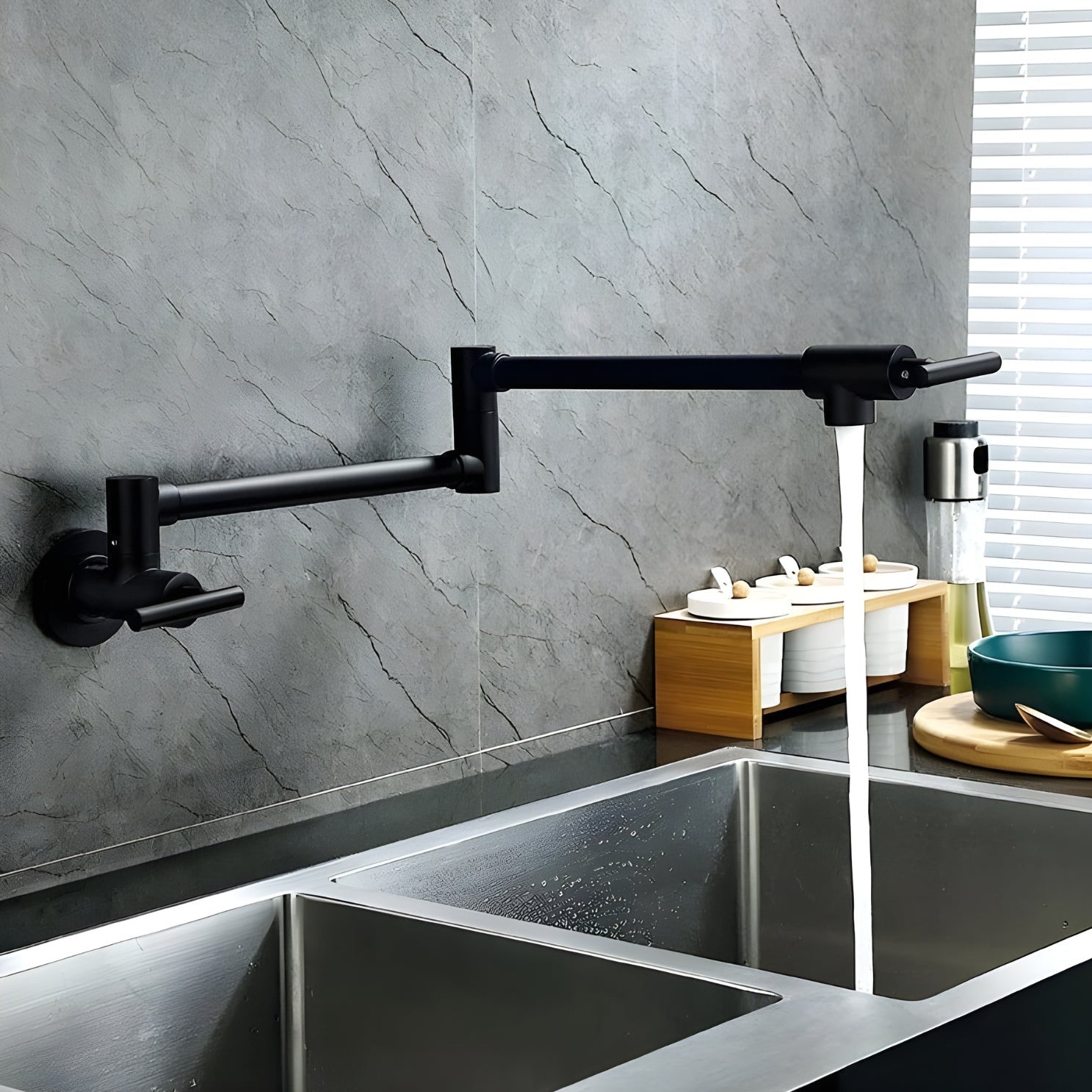 Modern kitchen sink with a black faucet against a gray marble wall.
