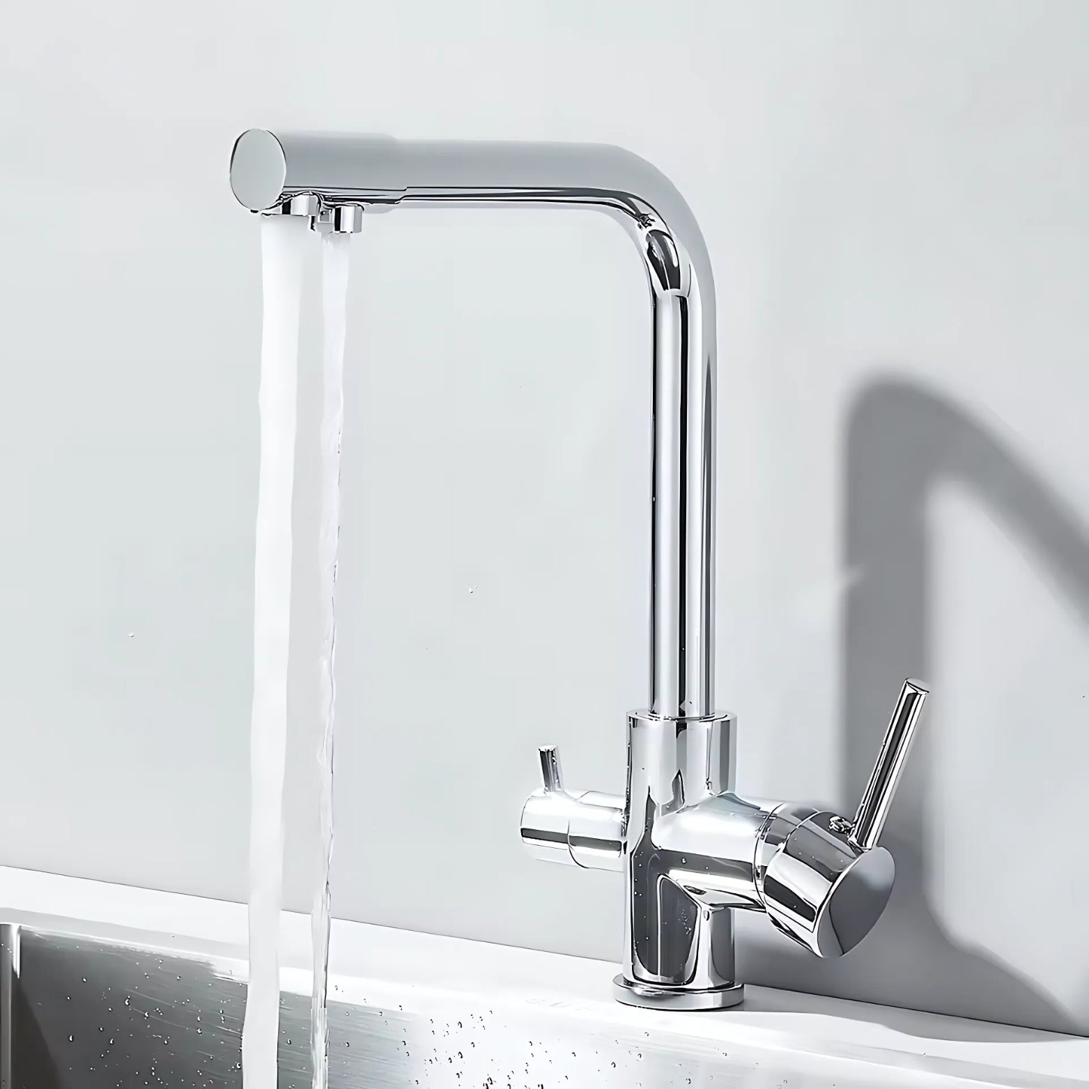 Chrome kitchen faucet with water flowing on a white background