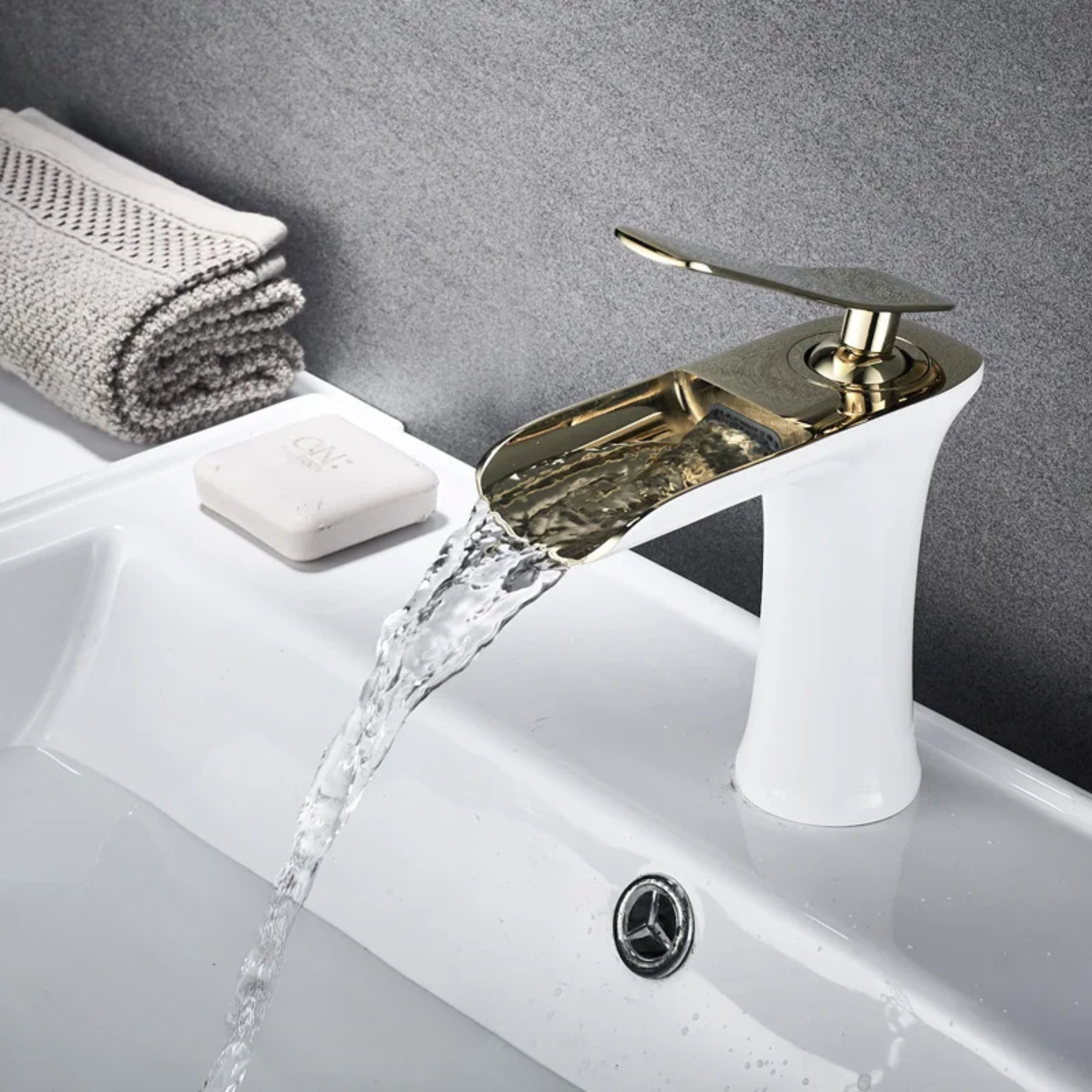 White and gold kitchen faucet attached to a sink, featuring a smooth, shiny finish for a modern and elegant look.